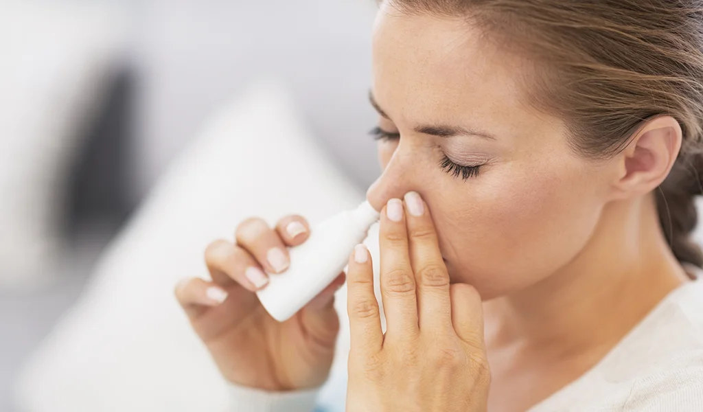Frau mit Nasentropfen